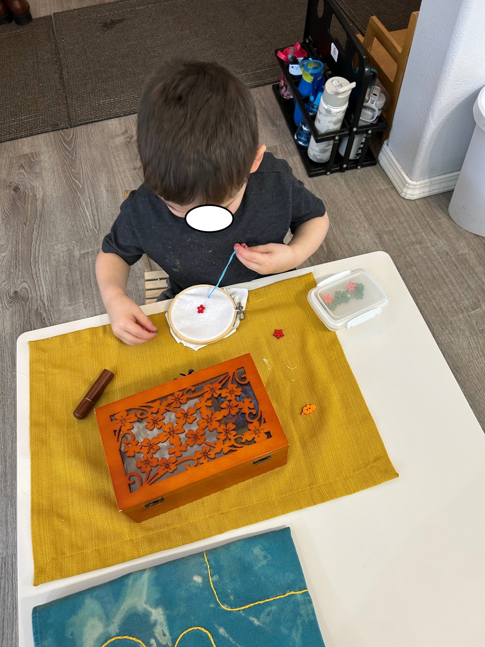 Child practicing embroidery at a Montessori table